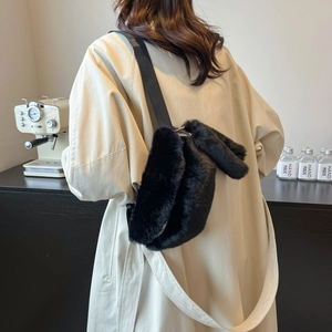 Detail of black faux fur shoulder bag with adjustable strap and soft plush texture