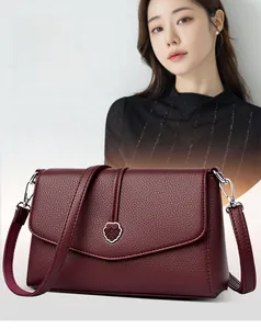 Détail du sac en cuir grainé bordeaux avec boucle métallique en forme de cœur