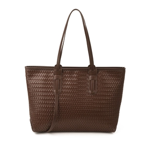 Grand sac cabas tressé marron foncé avec fines anses sur fond blanc professionnel