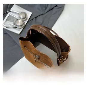 Détail du sac seau en daim marron avec cordon de serrage et vue intérieure spacieuse