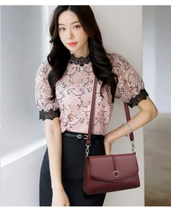 Vue détaillée du sac bandoulière en cuir bordeaux avec boucle fleurie sur un mannequin