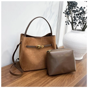 Ensemble sac seau en cuir givré marron et pochette assortie sur surface en bois