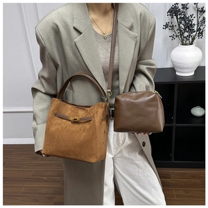 Détail du sac seau en daim caramel avec fermoir en métal et petite pochette bandoulière