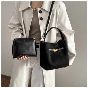 Détail du sac seau noir en daim mat avec fermoir doré et sa pochette intérieure