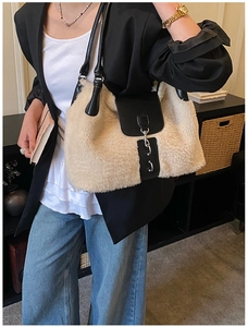 Detail of plush tote bag with black leather flap and silver buckle on shoulder strap