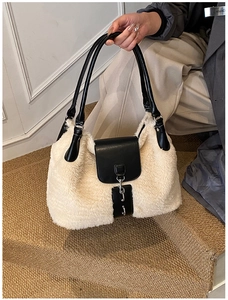 Detail of plush tote bag with black leather flap, silver buckle, and cream faux fur texture