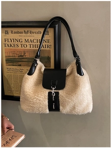Detail of trendy faux shearling and black leather crossbody bag with silver buckles