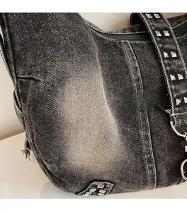 Gros plan sur le sac en denim délavé avec rivets argentés et coutures contrastées