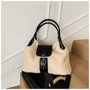 Detail of plush tote bag featuring cream faux fur texture and black leather strap design