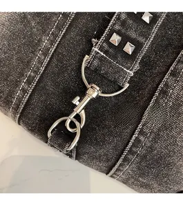 Détail du tissu denim foncé avec ferrures métalliques argentées et rivets brillants