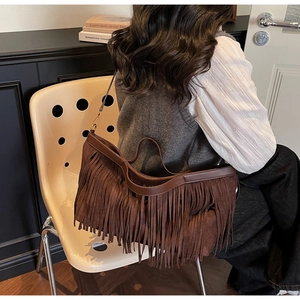 Détails macro du sac cabas bohème en daim marron foncé avec finitions à franges