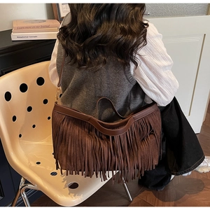 Détail d'un sac en daim marron avec de longues franges et bandoulière style rétro
