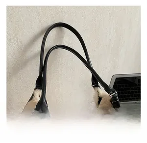 Detail of soft cream faux fur tote bag with sturdy black leather handles and metal rings