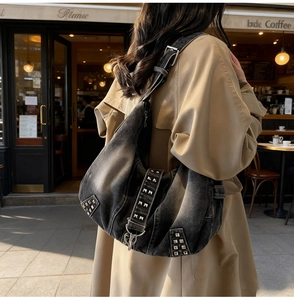 Détail du sac à bandoulière en denim gris délavé avec clous et boucle métallique