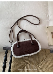 Detailansicht einer braunen Wildleder-Bowlingtasche mit Lammfellbesatz und Ledergriffen