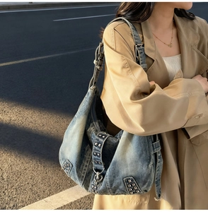 Détail du sac bandoulière en denim vintage avec rivets argentés et sangle réglable en tissu