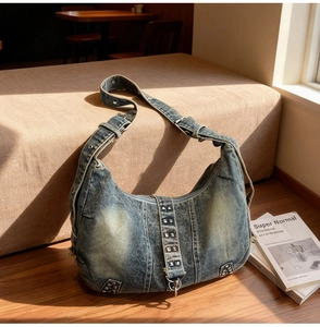 Détail du sac hobo en denim vintage avec rivets argentés sur la bandoulière et le corps