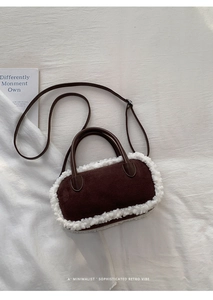 Detailaufnahme der braunen Wildleder-Tasche mit weißem Kunstpelzbesatz auf weißem Stoff