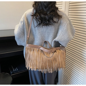 Détail d'un sac cabas en daim marron avec de longues franges et une bandoulière fine