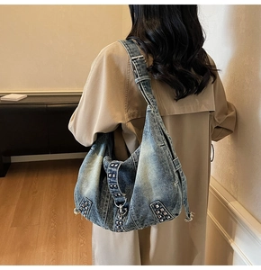 Détail du sac hobo en jean bleu avec clous argentés et large bandoulière réglable