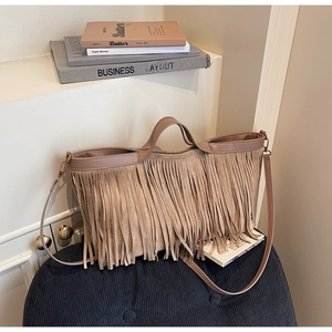 Détail d'un sac bandoulière marron mat avec de longues franges et une texture en daim