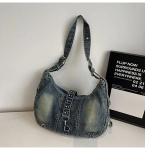 Détail du sac bandoulière en jean délavé avec clous carrés en métal et style vintage Y2K