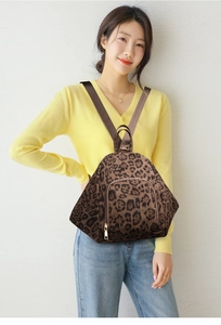 Detailed shot of a leopard print multi-functional backpack on a model with zipper detail