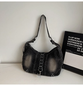 Détail du sac hobo en jean noir vintage avec clous argentés et bandoulière réglable