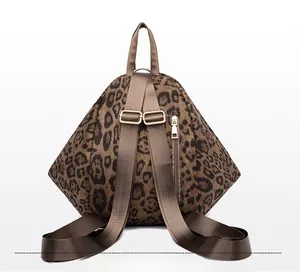 Detail of leopard print backpack with back zipper pocket and gold metal buckles