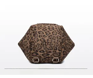 Detail view of leopard print backpack bottom featuring metal buckles and strap hardware