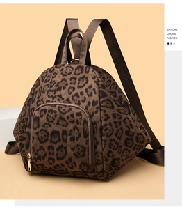 Detail of leopard print backpack showing front zipper pocket and gold-tone hardware
