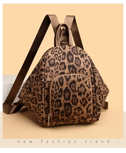 Detailed view of leopard print backpack with gold zipper and stylish front pocket compartment