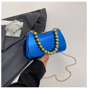Close-up of blue mirror acrylic evening bag with gold bead handle and metal chain strap