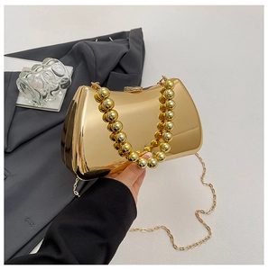 Detail of gold mirror evening clutch with large metallic bead handle and chain strap