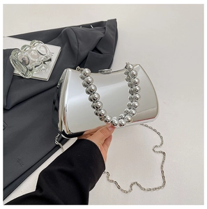 Detail of silver mirror evening clutch bag with beaded handle and metal chain strap