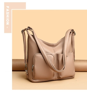 Close-up of litchi grain texture and front zip pockets on khaki crossbody bag