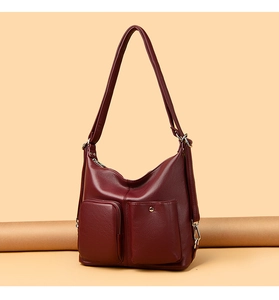 Detail of burgundy soft faux leather bag showing textured surface and metal pocket zippers