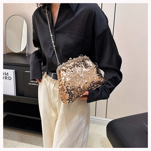 Macro view of golden sequin evening clutch bag with metal chain and vintage clasp