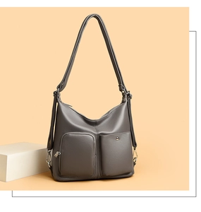 Detail view of the gray faux leather texture and functional front pockets of the shoulder bag