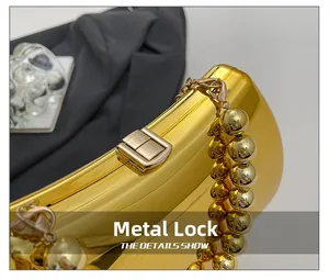 Detailed view of glossy gold evening clutch bag with hardware clasp and large bead chain