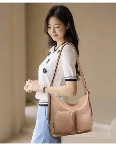 Chic khaki faux leather tote bag with pebble texture and dual front pockets on a model