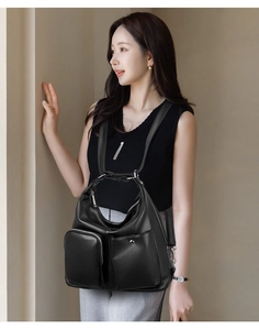 Detail of soft black leather bag with multiple zip pockets and premium hardware texture