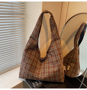 Detail of vintage checkered shoulder bag with button closure and retro plaid pattern