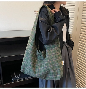 Detail of green checkerboard shoulder bag showing wool texture and woven label