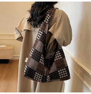 Detail of checkered tote bag with woven texture showing draped silhouette on model