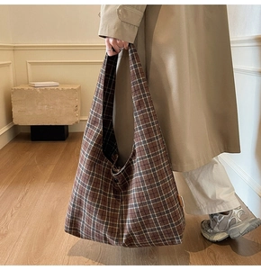 Detail of vintage brown checkered canvas tote bag with textured fabric and minimal tag
