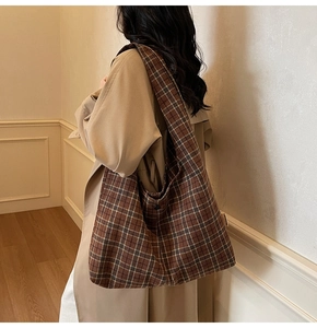 Detail shot of the large checkered shoulder bag with wide strap and button closure