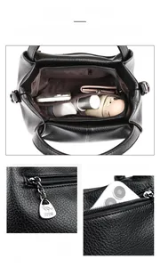 Detailed view of the multi-compartment interior and metal zipper puller of the black tote bag