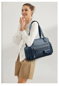 Detail of navy blue multi-pocket motorcycle bag with textured faux leather and zippers
