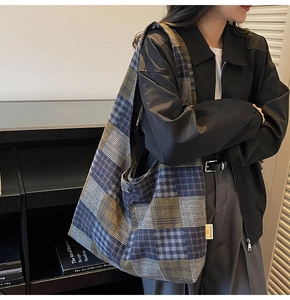 Detail view of large checkered tote bag with metal buckle and soft fabric texture